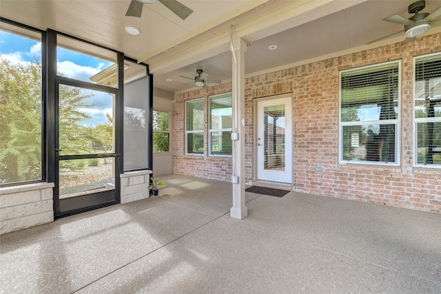 unfurnished sunroom featuring a healthy amount of sunlight and ceiling fan