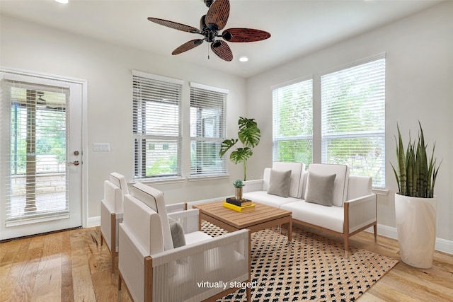 living room featuring ceiling fan, plenty of natural light, and light hardwood / wood-style floors