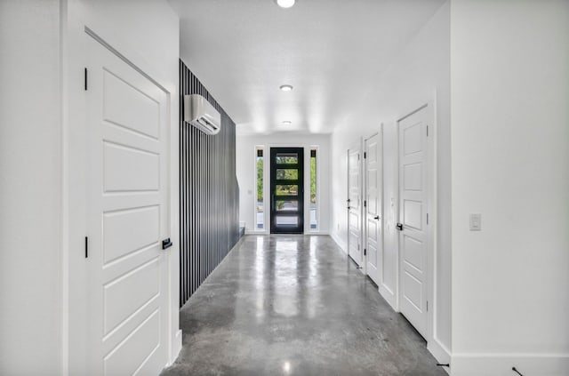 foyer entrance with french doors, an AC wall unit, and concrete floors