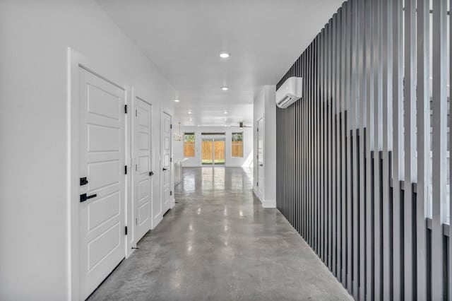 corridor featuring a wall mounted AC and concrete flooring