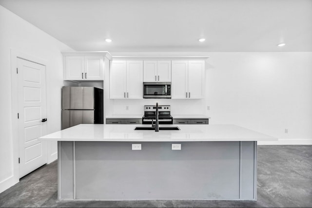 kitchen featuring white cabinets, concrete floors, appliances with stainless steel finishes, sink, and a kitchen island with sink