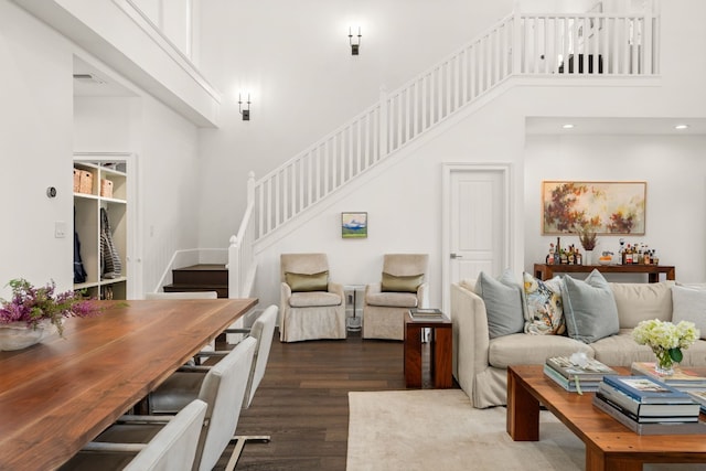 living room featuring a towering ceiling and hardwood / wood-style floors