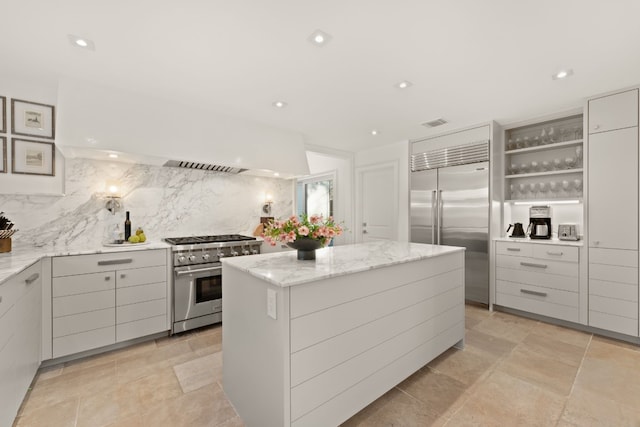 kitchen with tasteful backsplash, gray cabinetry, a kitchen island, high end appliances, and open shelves