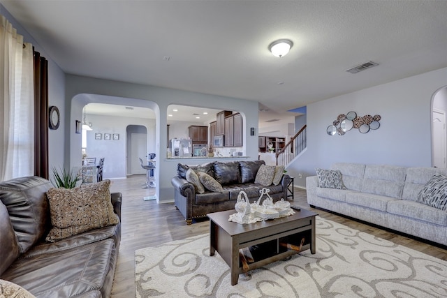 living room featuring a textured ceiling and light wood-type flooring