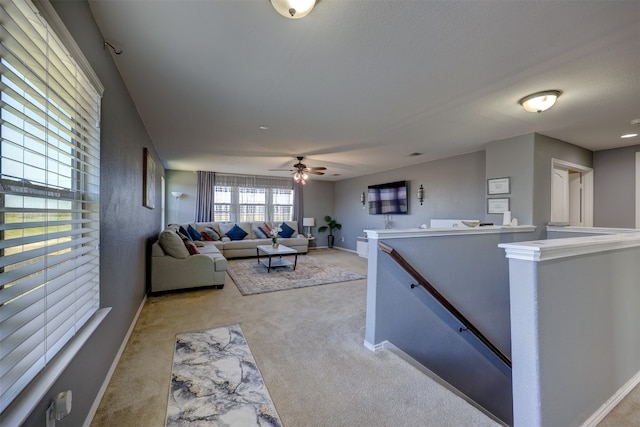 carpeted living room with ceiling fan