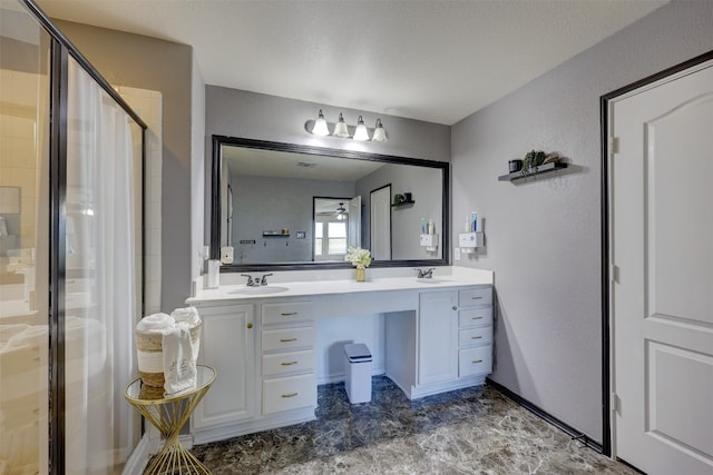 bathroom with a shower with door, vanity, and a textured ceiling