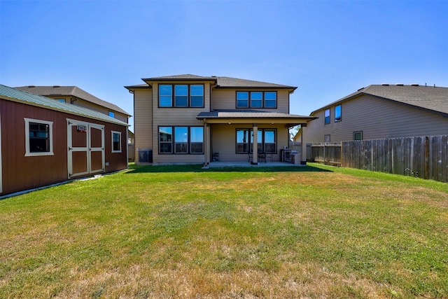 back of house with a patio area, a lawn, and central air condition unit