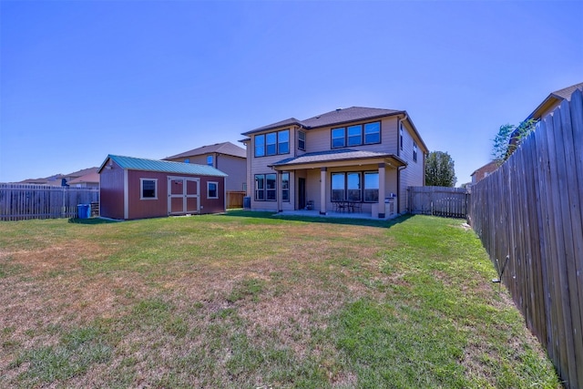 rear view of property with a yard and a shed