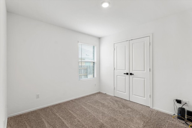 unfurnished bedroom with a closet and carpet floors