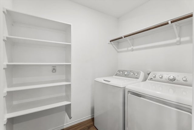 clothes washing area featuring washing machine and clothes dryer and dark hardwood / wood-style flooring