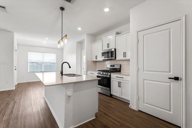 kitchen featuring pendant lighting, dark hardwood / wood-style flooring, stainless steel appliances, and white cabinets