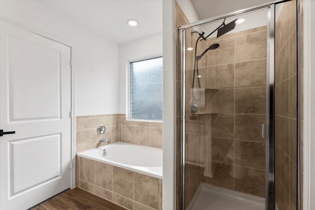 bathroom featuring wood-type flooring and plus walk in shower