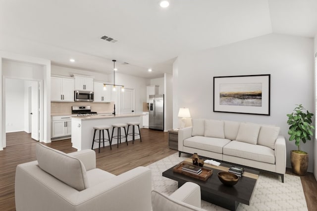 living room with lofted ceiling, dark hardwood / wood-style flooring, and sink