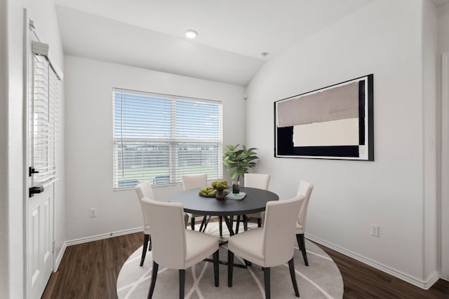 dining room featuring dark wood-type flooring and lofted ceiling