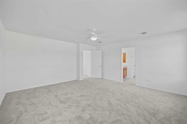 spare room featuring ceiling fan and light colored carpet