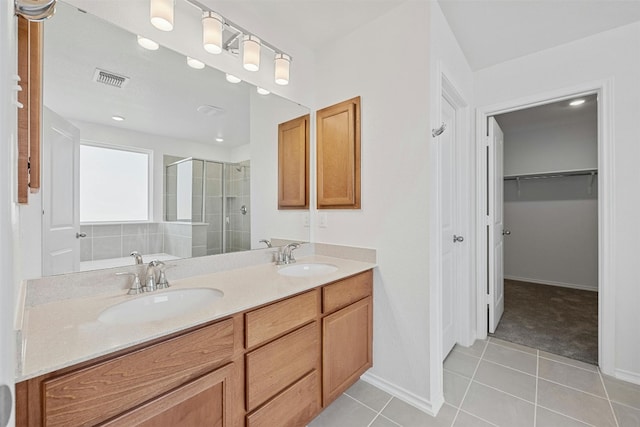 213 Skipping Stone Run, Georgetown, TX 78628 - full bathroom with a shower stall, double vanity, a walk in closet, and tile patterned floors