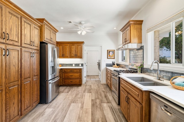 kitchen featuring sink, light hardwood / wood-style flooring, stainless steel appliances, backsplash, and ceiling fan