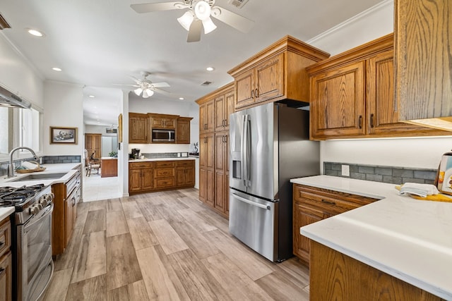 kitchen featuring ceiling fan, appliances with stainless steel finishes, light wood-type flooring, and sink