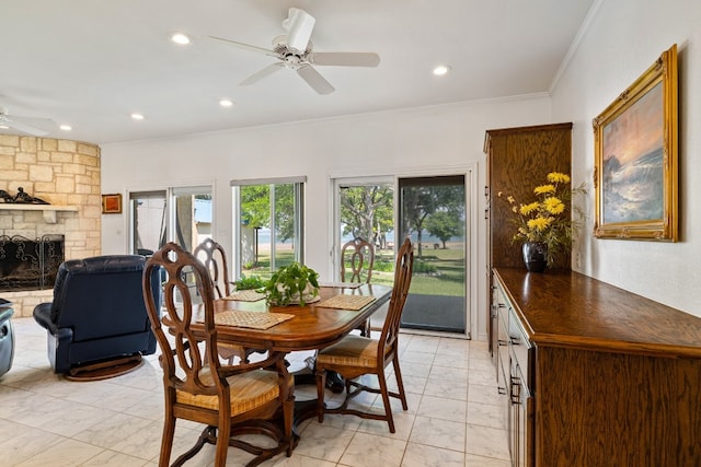 dining room featuring ceiling fan, a fireplace, and crown molding