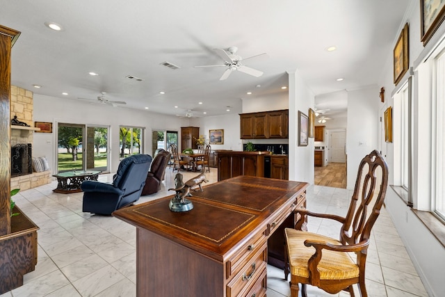 interior space with ceiling fan and a fireplace