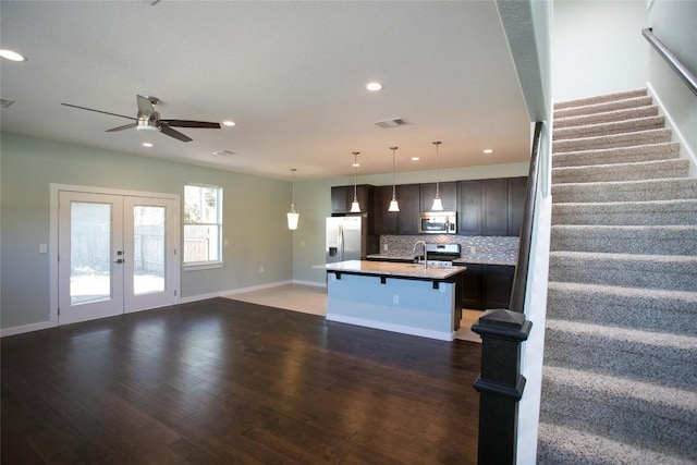 kitchen featuring decorative backsplash, french doors, open floor plan, and stainless steel appliances