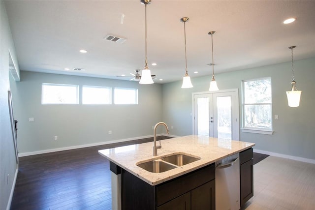 kitchen with a sink, dishwasher, open floor plan, and recessed lighting