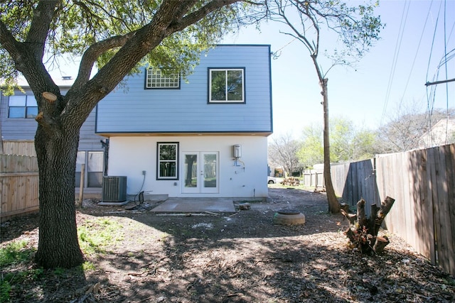 back of property with central AC unit and french doors