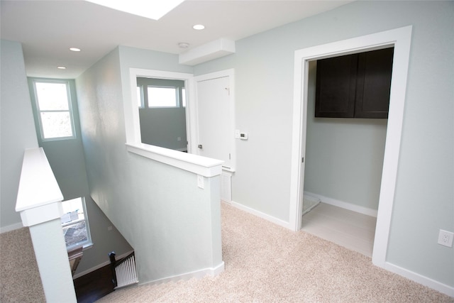 hallway featuring light colored carpet