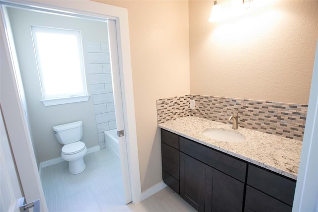 full bath featuring tasteful backsplash, toilet, vanity, and baseboards