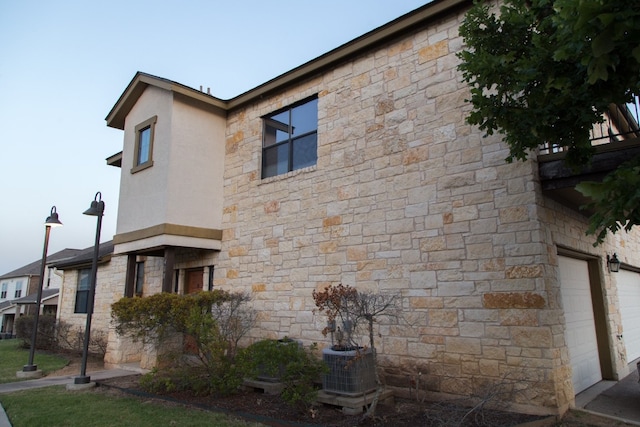 view of home's exterior with a garage and central air condition unit