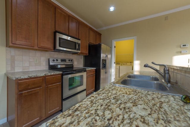2101 Town Centre Dr Unit 1408, Round Rock, TX 78664 - kitchen featuring stainless steel appliances, washer and dryer, crown molding, decorative backsplash, and a sink