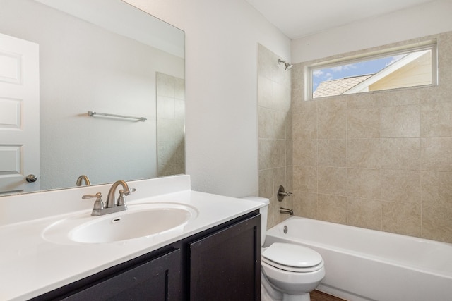 full bathroom with tiled shower / bath combo, vanity, and toilet