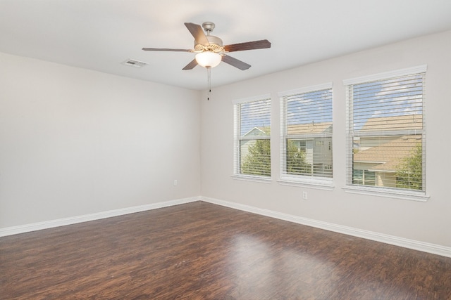 empty room with dark hardwood / wood-style flooring and ceiling fan