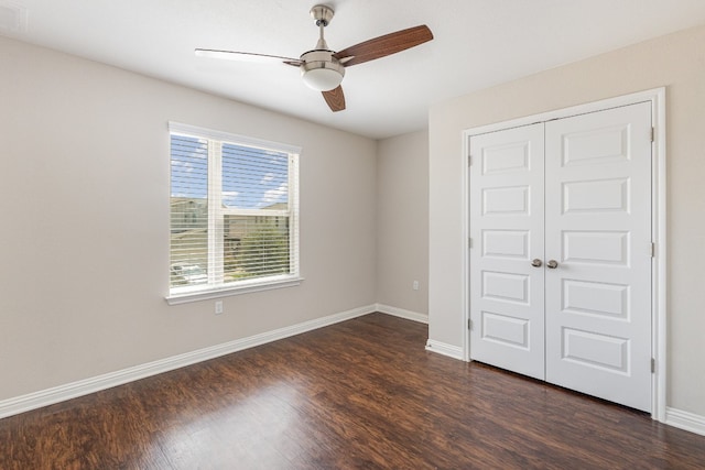 unfurnished bedroom with ceiling fan, a closet, and dark hardwood / wood-style flooring