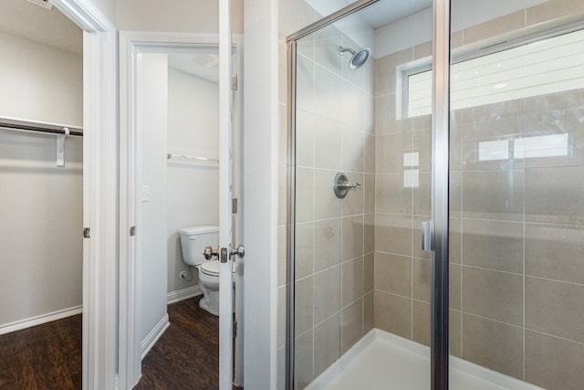 bathroom with toilet, hardwood / wood-style floors, and an enclosed shower