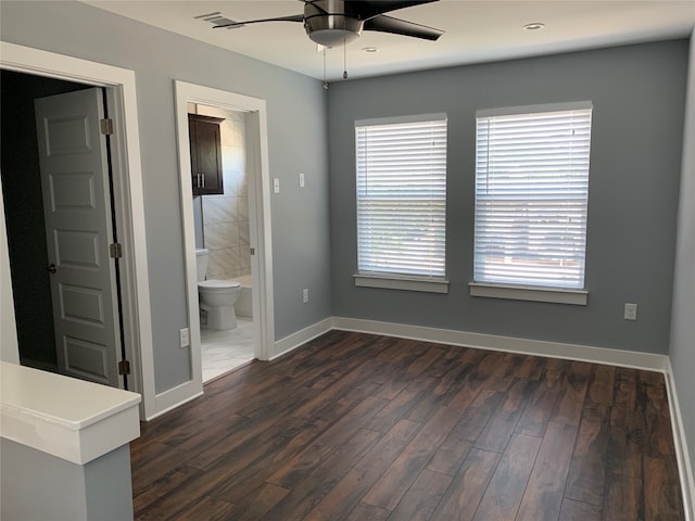 unfurnished bedroom featuring dark wood-type flooring, ceiling fan, and ensuite bathroom