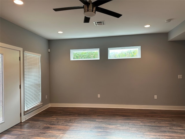 empty room featuring dark wood-type flooring, ceiling fan, and a healthy amount of sunlight