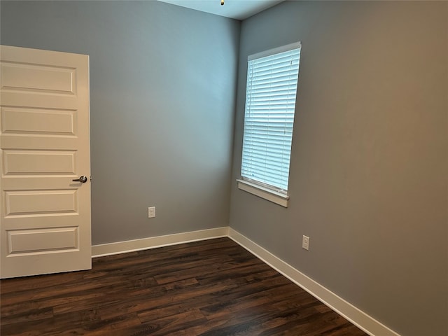 unfurnished room with dark wood-type flooring and plenty of natural light