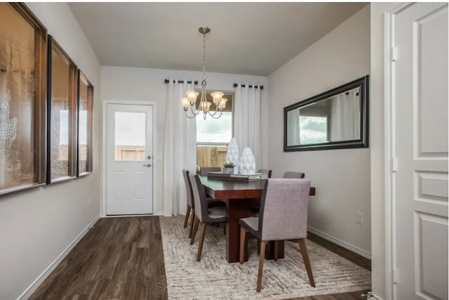 dining area with dark wood-type flooring and a chandelier