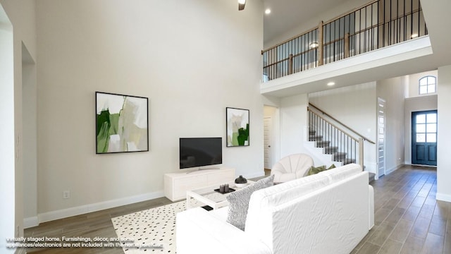 living room with hardwood / wood-style flooring and a high ceiling