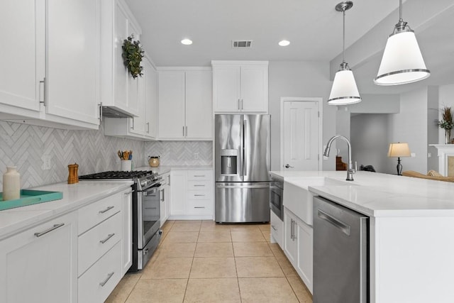 kitchen with white cabinets, hanging light fixtures, and appliances with stainless steel finishes