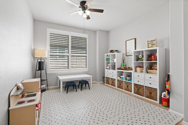 playroom with ceiling fan and light carpet