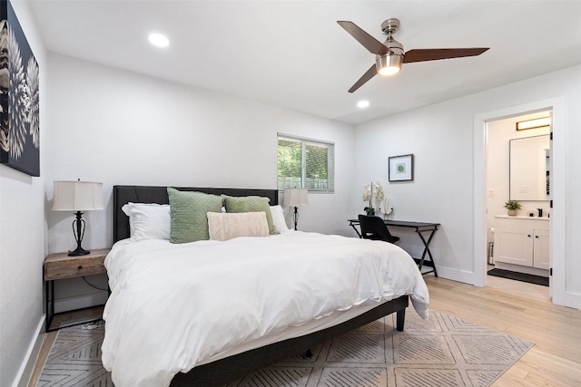 bedroom featuring ensuite bath, ceiling fan, and light hardwood / wood-style flooring