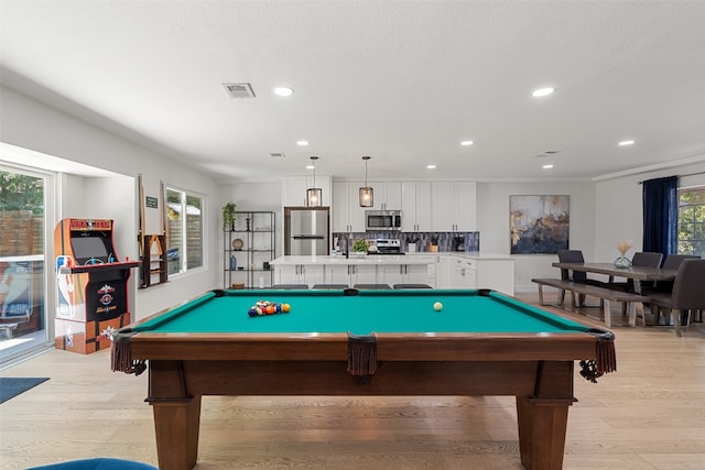 rec room with ornamental molding, light hardwood / wood-style flooring, a healthy amount of sunlight, and pool table