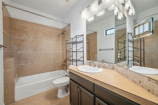 full bathroom featuring tile patterned flooring, toilet, tiled shower / bath combo, and vanity