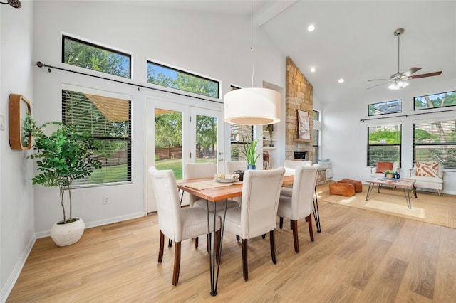 dining room featuring a healthy amount of sunlight, ceiling fan, high vaulted ceiling, and light hardwood / wood-style floors