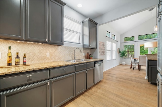 kitchen with light hardwood / wood-style flooring, sink, light stone countertops, lofted ceiling, and stainless steel dishwasher