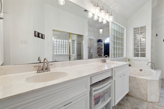 bathroom with lofted ceiling, vanity, and a bathing tub