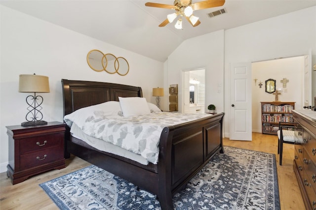 bedroom featuring light wood-type flooring, lofted ceiling, connected bathroom, and ceiling fan