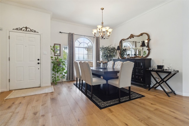 dining space with light wood-type flooring, a chandelier, and ornamental molding